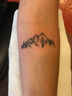 a small tattoo on the arm with trees and mountains in the background that reads small camping tattoos best of little