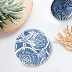 a blue plate sitting on top of a white table next to a plant and other items