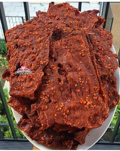 a white plate topped with meat next to a fence