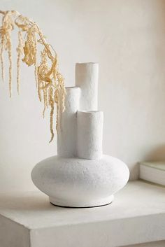 a white vase sitting on top of a table