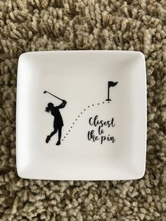 a white plate with a black silhouette of a person swinging a golf club on it