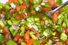 a white bowl filled with chopped vegetables and a spoon sticking out of the soup in it