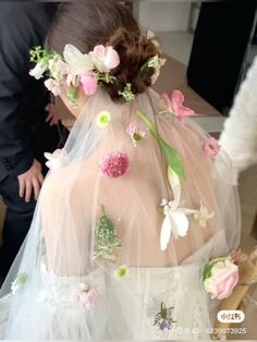 a woman wearing a veil with flowers on it