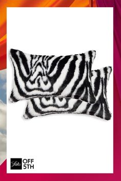 two black and white zebra print pillows against a blue sky with clouds in the background