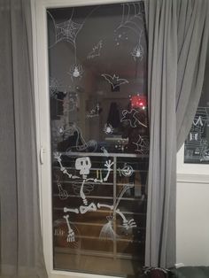 the window is decorated with skeletons and spider webs on it's glass door