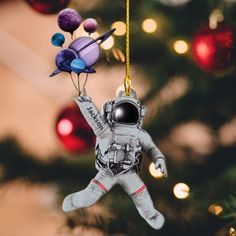 an ornament hanging from a christmas tree with the astronaut in space on it