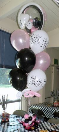 a table topped with lots of balloons and black and white tablespread covered in checkered cloths