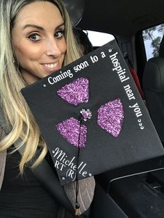 a woman holding up a book in the back seat of a car with glitter bows on it