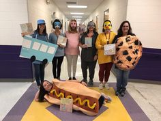 group of people standing in hallway holding signs with hot dogs on them and mcdonald's costume