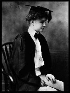 an old black and white photo of a young woman in graduation gown sitting on a chair