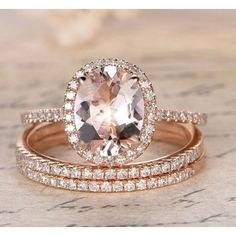 two rose gold wedding rings with an oval cut morganite surrounded by smaller round diamonds