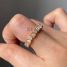 a woman's hand with a diamond ring on her left side and the other half of her finger