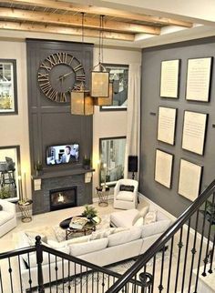 a living room filled with furniture and a fire place under a clock mounted on the wall