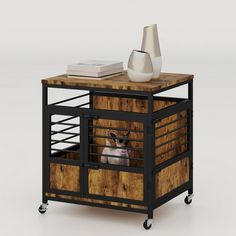 a small dog in a cage on top of a wooden table next to a white vase