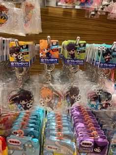 some anime key chains are on display in a store with plastic bags and other items