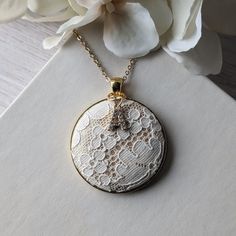 This vintage lace necklace is the perfect gift for those that love a timeless and elegant style. The white floral lace from the 1950s evokes a sense of delicate beauty, with a background of shiny gold satin that highlights the intricate lace design. It's set in a gold metallic metal alloy pendant, with a dainty gold stainless steel chain that measures 22 inches in total length. Letter charm: The finishing touch is the capital letter initial charm that adorns the top of the pendant. This charm offers the perfect way to make this necklace a thoughtful and personalized gift. Gift box: The necklace will be packaged in a stylish, branded gift box, ready to be presented with love and care.  Gift notes:  Write a personalized note to your loved one at checkout, and it will be printed on decorative White Vintage Necklaces For Vintage Events, Elegant Lace Jewelry For Gifts, Victorian White Necklace For Anniversary, Vintage White Bridal Necklace Formal Occasion, Vintage White Bridal Necklace For Formal Occasions, Delicate White Bridal Necklace For Anniversary, Elegant Vintage Charm Necklace For Anniversary, Vintage Lace Jewelry For Gifts, White Feminine Jewelry For Anniversary