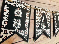 a leopard print banner hanging on a wall next to a wooden planked wall with black and white letters that spell out the word laf