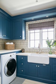 a washer and dryer in a kitchen with blue cabinets