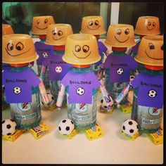 a group of children's bottles with faces drawn on them and soccer balls around them