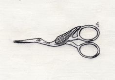 a pair of scissors sitting on top of a piece of white paper with black thread