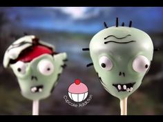 two green zombie lollipops with spooky eyes and black hair on them