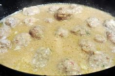 meatballs and gravy are being cooked in a skillet