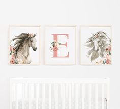 two horse prints hanging on the wall next to a crib with a baby's bed