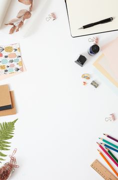 an overhead view of various stationery items on a white surface