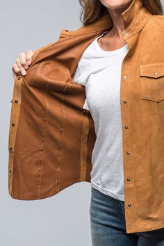 a woman wearing a tan leather jacket