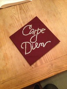 a graduation cap with the words escape and dream on it sitting on top of a wooden table