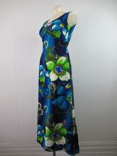 "Vintage 1960s Hawaiian dress. Made of blue cotton with floral pattern. Has empire waist and back zipper. Made ands styled in Hawaii by Royal Hawaiian. About a size small. Measurements are: 35\" around the bust 25\" around the waist 37\" around the hips 14.5\" shoulder to shoulder 51\" overall length In very good condition." Blue Retro Dress For Garden Party, Retro Blue Dress For Garden Party, Retro Blue Maxi Dress For The Beach, Fitted Blue Dress With Retro Print, Blue Retro Dress With Retro Print, 1970s Style Blue Floral Print Dresses, Blue Sleeveless Vintage Maxi Dress, Vintage Blue Maxi Dress For Garden Party, Blue Lined Maxi Dress For Garden Party