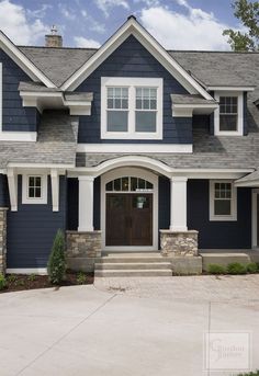 a house with blue siding and white trim on the front door is shown in an instagram