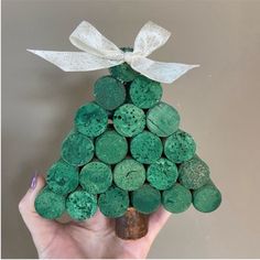 a hand holding a bottle cork christmas tree