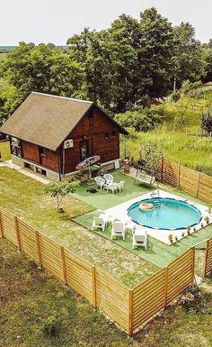 an aerial view of a backyard with a pool in the middle and a wooden fence surrounding it