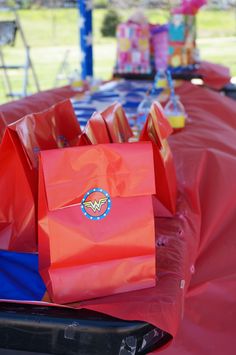 red bags sitting on top of a table covered in blue and red plastic bag liners