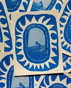 several blue and white stickers with a man surfing on a wave in the ocean