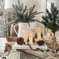 christmas decorations are sitting on top of books in front of a mirror and other items