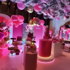 a room filled with lots of balloons and tables covered in pink, white and gold decorations