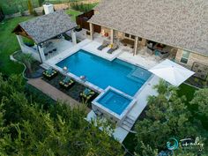 an aerial view of a house with a pool in the yard and covered patio area