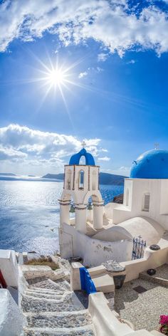 the sun shines brightly over an old church by the water's edge with steps leading up to it