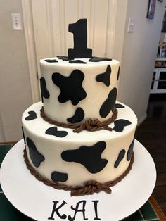 two tiered cake decorated with black and white cow print