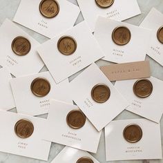 many different types of coins are on top of white cards with brown ink and paper