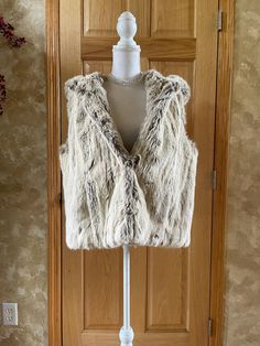 STUNNING soft faux fur vest by Ralph Lauren. Size 1X. It features 2 frog hooks for closures and side pockets witha beautiful hood. Beautiful golden quilted lining with an inner pcoket and a chain for hanging it up at the inner collar.  Length is 26" and Chest is 42.  Fully lined, 2 frog hook closure, side pockets, one interior pocket size 1X      Label: Ralph Lauren Tag Size: 1X Measurements: Length:  26"  Chest:  42" Material: Faux fur: shell 80% acrylic / 20% modacrylic, back 100% cotton   Lining 100% acetate padding is 100% polyester Dry clean only Made in China Condition:  excellent Please review the photos carefully.  We examine each item carefully and do our best to note imperfections.  Please understand that vintage items are not new. All items are pre-loved and sold AS-IS. Thank yo Fur Vest Pattern, Vest Pattern, Faux Fur Vest, Faux Fur Vests, Fur Vest, Pocket Size, Faux Fur, Vintage Items, Dry Clean