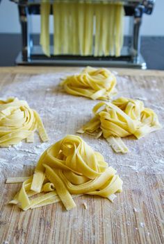 some uncooked pasta sitting on top of a wooden table next to a toaster