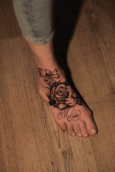 a woman's foot with a rose tattoo on it