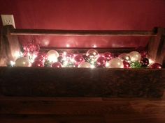 a wooden crate filled with ornaments and lights