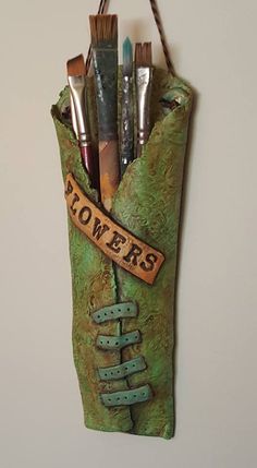 there is a green bag with some paintbrushes in it and the words powers on it