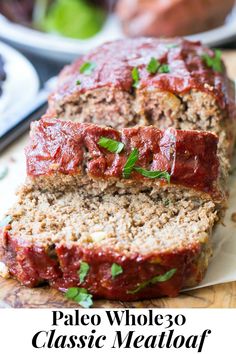 two slices of meatloaf on a cutting board with the text pale whole 30 classic meatloaf