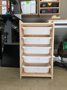 several white containers are stacked on top of each other in front of a workbench