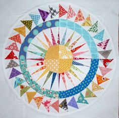 a white table cloth with colorful flags on it and a circular design in the center